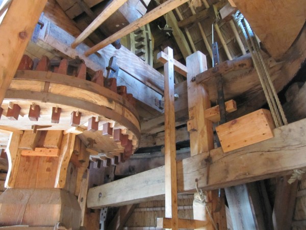 The brake is operated by a giant lever which weight constricts the wooden blocks against the wheel. This lever is operated by the long stick you see coming out the back of the cap on previous pictures.