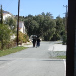 Two monks walk along the entrance to a monestery